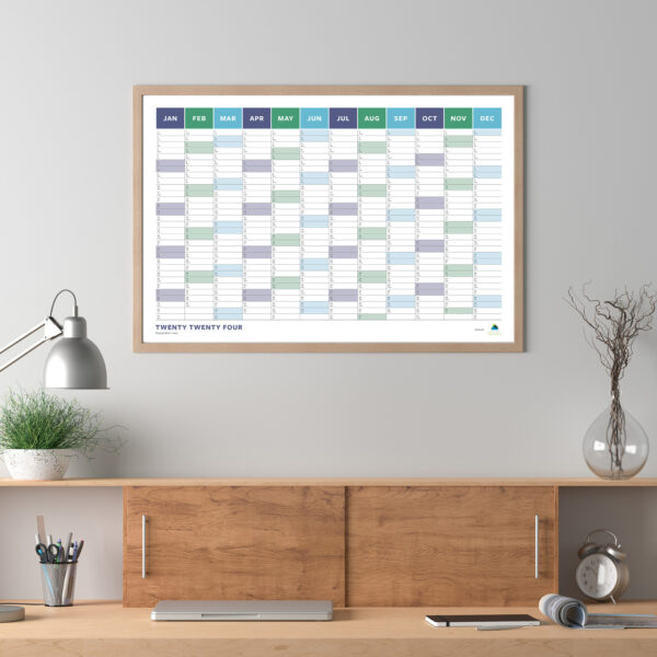 A 2024 Wall Calendar (Blue/Green) hanging above a desk in a home office.